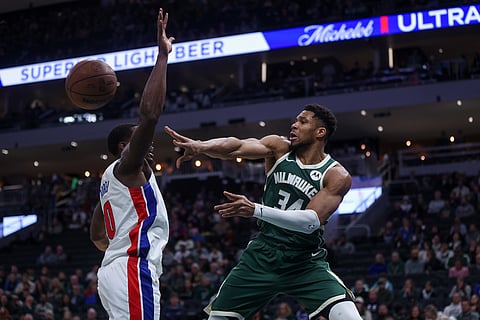 Milwaukee Bucks' Giannis Antetokounmpo passes against Detroit Pistons' Jalen Duren during the first half an NBA basketball game in Milwaukee. 
