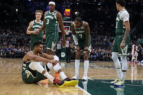 Milwaukee Bucks' Giannis Antetokounmpo reacts after suffering an injury during the first half an NBA basketball game against the Detroit Pistons, in Milwaukee. 