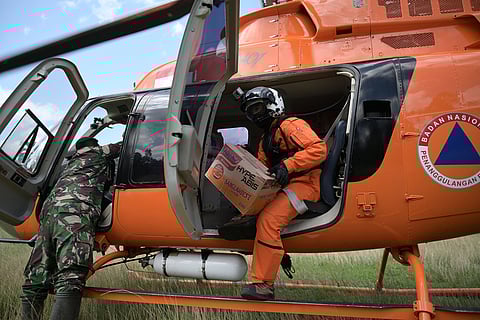 Crew unload relief goods from a national disaster mitigation agency's helicopter during an aerial aid distribution in a flood affected area in North Aceh, Indonesia.