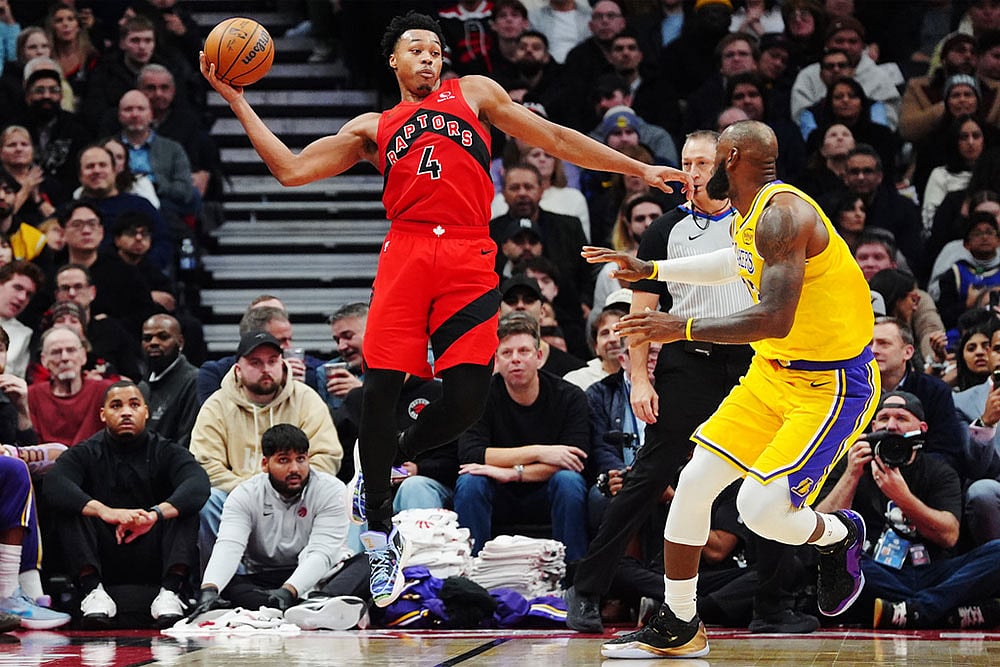| Frank Gunn/The Canadian Press via AP : Toronto Raptors' Scottie Barnes (4) looks to pass the ball over Los Angeles Lakers' LeBron James, right, during second-half NBA basketball game action in Toronto.
