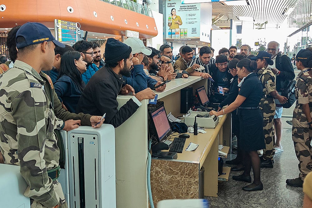 Passengers enquire about their IndiGo flight at a boarding gate at Kempegowda International Airport amid flight disruptions, in Bengaluru. IndiGo's operations crumbled as pilot-rostering issues continued to force large scale flight cancellations -- over 400 on Friday -- and many passengers have been stranded for as long as three days at airports. - Photo: PTI/Shailendra Bhojak