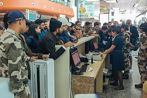 Passengers enquire about their IndiGo flight at a boarding gate at Kempegowda International Airport amid flight disruptions, in Bengaluru. IndiGo's operations crumbled as pilot-rostering issues continued to force large scale flight cancellations -- over 400 on Friday -- and many passengers have been stranded for as long as three days at airports.