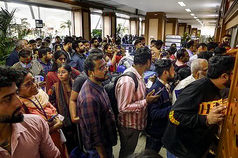 Stranded passengers wait in queues to enquire about flight status at Sardar Vallabhbhai Patel International Airport amid IndiGo flight disruptions, in Ahmedabad.