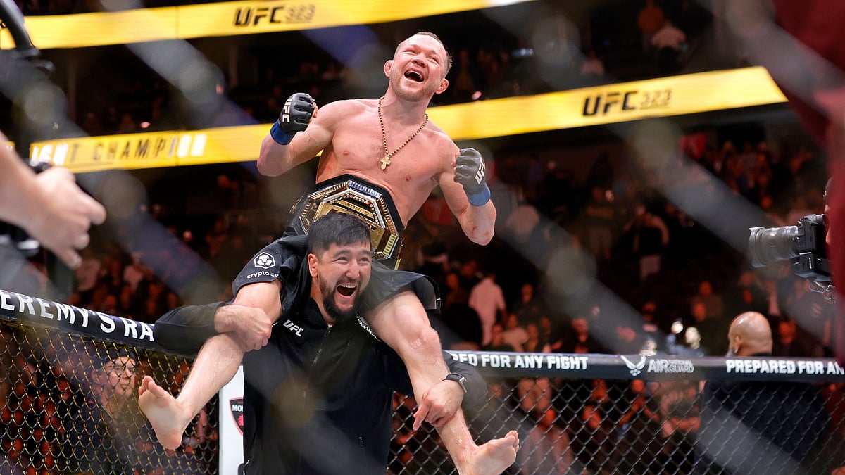 Petr Yan celebrates with a member of his team after defeating UFC bantamweight champion Merab Dvalishvili during UFC 323 - AP/Steve Marcus