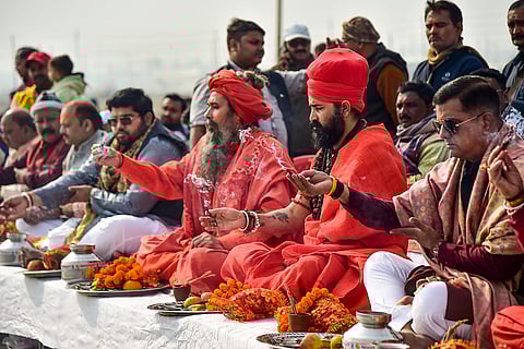 Mahant of Baghambari Math Balveer Giri Maharaj, second from right, with monks and other people performs the 'Ganga Pujan' ritual for the upcoming 'Magh Mela 2026', at the Sangam in Prayagraj.