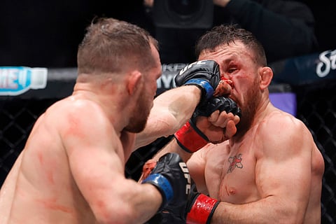 Petr Yan, left, punches UFC bantamweight champion Merab Dvalishvili during UFC 323 in Las Vegas.