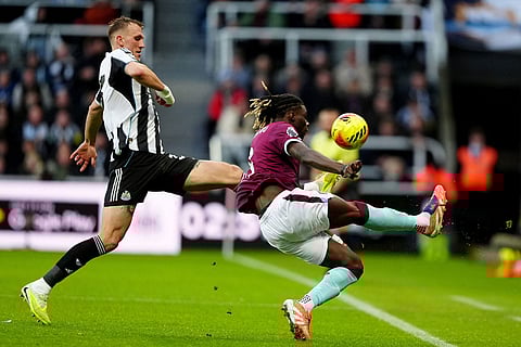 Newcastle United's Dan Burn, left, and Burnley's Lesley Ugochukwu battle for the ball during the English Premier League soccer match between Newcastle United and Burnley in Newcastle upon Tyne, England.