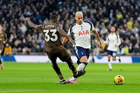 Brentford's Michael Kayode, left, and Tottenham Hotspur's Richarlison challenge for the ball during  during the English Premier League soccer match between Tottenham Hotspur and Brentford in London.