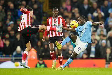 Sunderland's Ahmed Abdullahi, left, challenges for the ball with Manchester City's Jeremy Doku, right, during the English Premier League soccer match between Manchester City and Sunderland in Manchester, England.