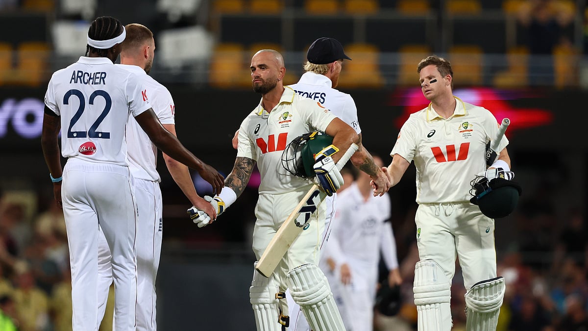 (AP Photo/Tertius Pickard) : Australia's Jake Weatherald, front, and Australia's captain Steve Smith shake hands with England's players after winning the second Ashes cricket test match between Australia and England in Brisbane, Sunday, Dec. 7, 2025. 