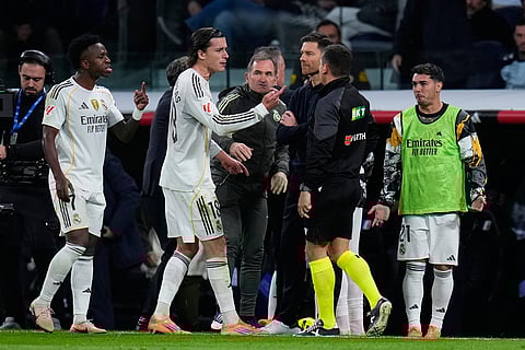 Real Madrid's Alvaro Carreras, center, argues with the fourth official after getting a red card during the Spanish La Liga soccer match between Real Madrid and Celta Vigo in Madrid, Spain.