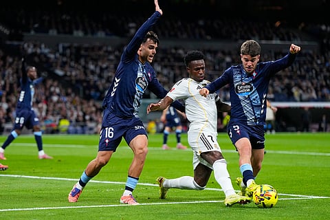 Real Madrid's Vinícius Júnior is challenged by Celta's Sergio Carreira, right, and Miguel Roman during the Spanish La Liga soccer match between Real Madrid and Celta Vigo in Madrid, Spain.