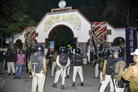 Security personnel stand guard as students block the exit during a protest against alleged irregularities by Vice Chancellor Shambhu Nath Singh at Tezpur University, in Sonitpur district, Assam.