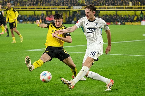 Borussia's Aaron Anselmino, left, and Hoffenheim's Wouter Burger challenge for the ball during Germany Bundesliga soccer match between Borussia Dortmund and TSG 1899 Hoffenheim, in Dortmund, Germany.