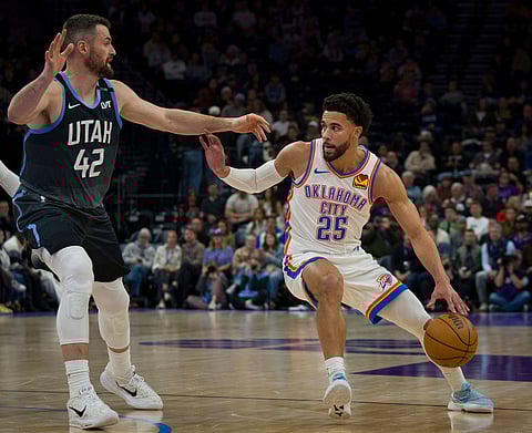 Oklahoma City Thunder guard Ajay Mitchell (25) dribbles as Utah Jazz forward/center Kevin Love (42) defends during the first half of an NBA basketball game in Salt Lake City.