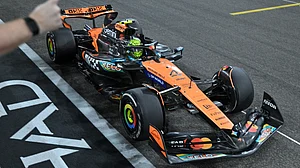 | Photo: Pool/Andrej Isakovic via AP : McLaren driver Lando Norris crosses the finish line to become the world champion during the Formula 1 Abu Dhabi Grand Prix on December 7, 2025.