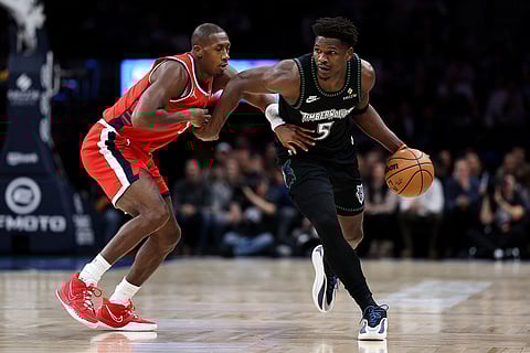 Minnesota Timberwolves guard Anthony Edwards, right, works around Los Angeles Clippers guard Kris Dunn (8) during the first half of an NBA basketball game  in Minneapolis.