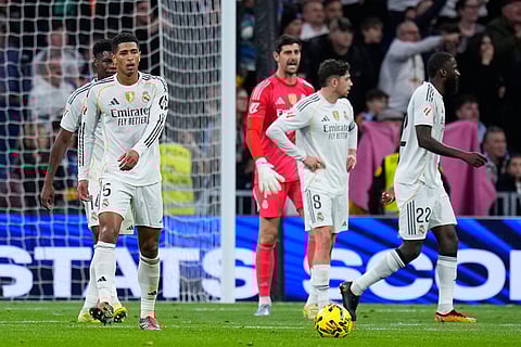 Real Madrid's Jude Bellingham, left, and teammates react after Celta's Williot Swedberg scored his side's second goal during the Spanish La Liga soccer match between Real Madrid and Celta Vigo in Madrid, Spain.