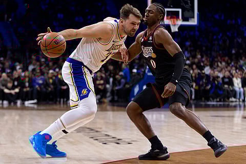 Los Angeles Lakers' Luka Doncic, left, makes his move against Philadelphia 76ers' Tyrese Maxey during the first half of an NBA basketball game in Philadelphia.