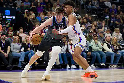 Utah Jazz center Kyle Filipowski, left, dribbles around Oklahoma City Thunder forward Ousmane Dieng during the second half of an NBA basketball game in Salt Lake City.