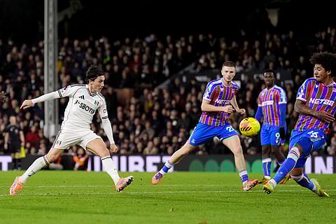 Fulham's Harry Wilson, left, scores his sides first goal during the English Premier League soccer match between Fulham and Crystal Palace, in London.
