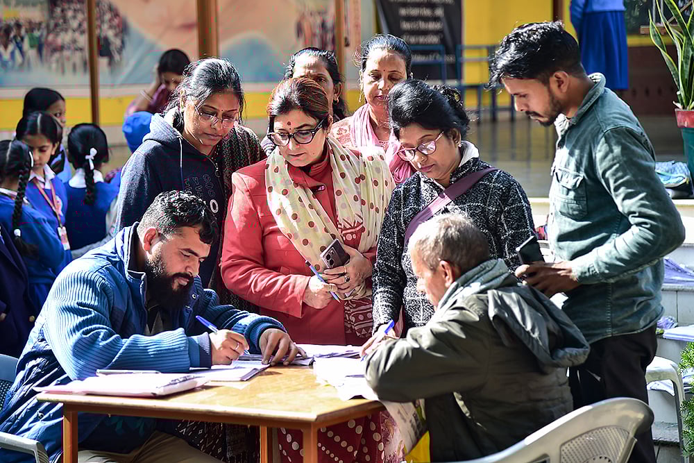 Booth Level Officers (BLOs) collect enumeration forms from voters. - PTI; Representative image