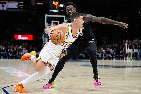 Phoenix Suns guard Collin Gillespie, front, works toward the basket as Minnesota Timberwolves forward Julius Randle defends during the second half of an NBA basketball game in Minneapolis. 