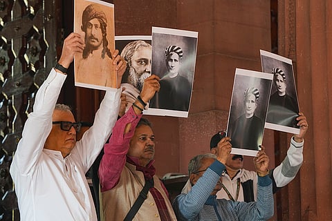 TMC leaders hold a silent protest against the government holding photos of Bankim Chandra Chatterjee and Rabindranath Tagore during the Winter session of Parliament, in New Delhi.