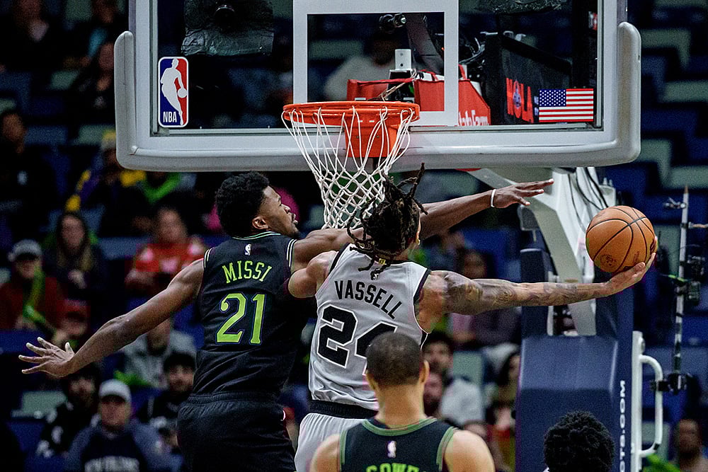 New Orleans Pelicans center Yves Missi (21) fouls San Antonio Spurs guard/forward Devin Vassell (24) during the first half of an NBA basketball game in New Orleans. - | Photo: AP/Matthew Hinton