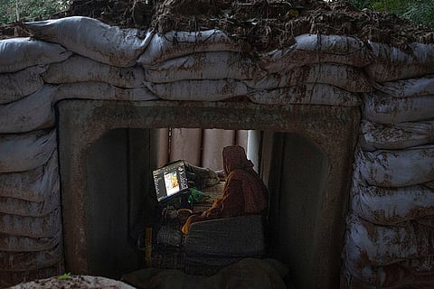 A Thai Buddhist monk uses his computer while taking shelter in Buriram province, Thailand after he fled clashes between Thai and Cambodian soldiers. 