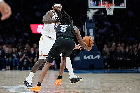 Minnesota Timberwolves guard Bones Hyland (8) steals the ball from Phoenix Suns forward Royce O'Neale, left, during the second half of an NBA basketball game in Minneapolis. 