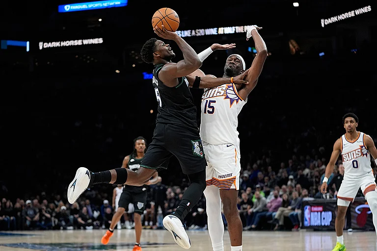 Minnesota Timberwolves guard Anthony Edwards (5) shoots over Phoenix Suns center Mark Williams (15) during the first half of an NBA basketball game in Minneapolis. - | Photo: AP/Abbie Parr