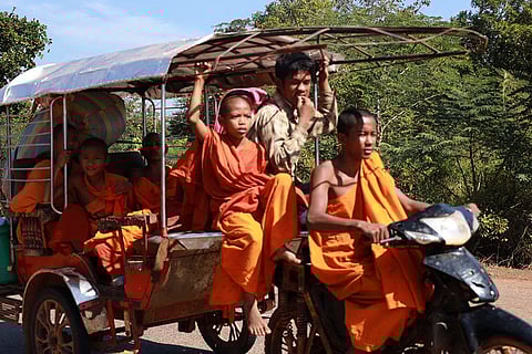 In this photo released by Agence Kampuchea Press (AKP), Cambodian Buddhist monks sit on a motor cart as they flee from their pagoda of Preah Vihear province, near the border with Thailand.