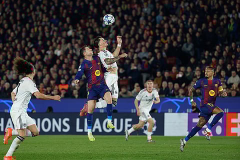 Barcelona's Robert Lewandowski, left, and Frankfurt's Robin Koch jump for a high ball during the Champions League opening phase soccer match between Barcelona and Eintracht Frankfurt in Barcelona, Spain.