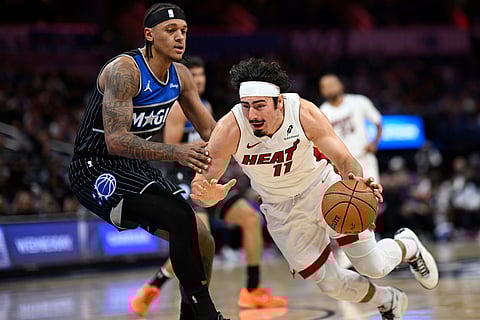Miami Heat forward Jaime Jaquez Jr. (11) drives to the basket as Orlando Magic forward Paolo Banchero, left, defends during the first half of an NBA Cup basketball game in Orlando, Florida.