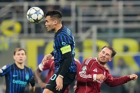 Inter Milan's Lautaro Martinez, left, jumps for a header with Liverpool's Alexis Mac Allister during a Champions League, league phase, soccer match between Inter Milan and Liverpool in Milan, Italy.