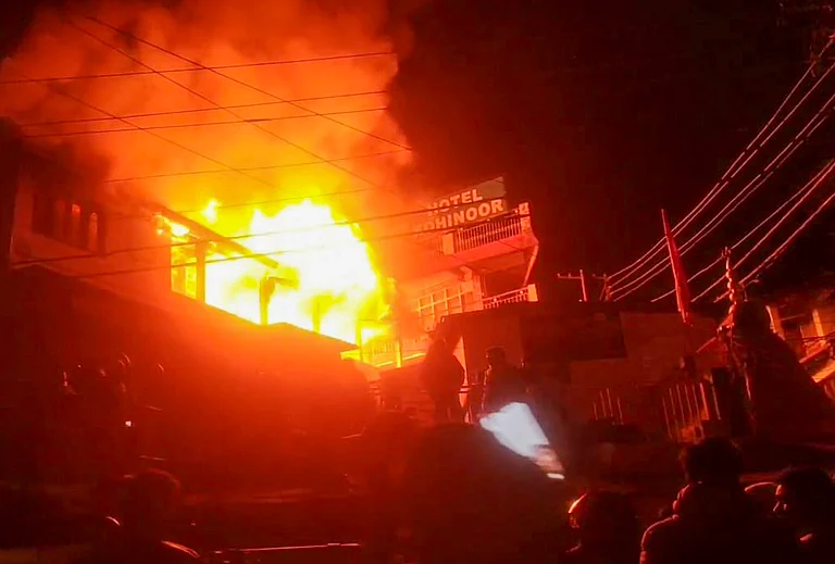 Nainital: Smoke and flames billow out after a fire broke out at British-era building, housing Saraswati Shishu Mandir school, in Nainital, Tuesday night, Dec. 9, 2025. - (PTI Photo)