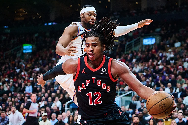 Toronto Raptors' Collin Murray-Boyles (12) drives past New York Knicks' Guerschon Yabusele (28) during the first half of an NBA Cup basketball game in Toronto. - | Photo: Sammy Kogan/The Canadian Press via AP