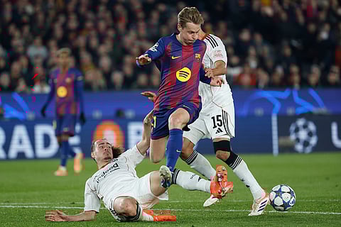 Barcelona's Frenkie de Jong, center, is tackled by Frankfurt's Arthur Theate during the Champions League opening phase soccer match between Barcelona and Eintracht Frankfurt in Barcelona, Spain.