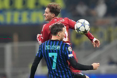 Liverpool's Alexis Mac Allister jumps for a header with Inter Milan's Piotr Zielinski during a Champions League, league phase, soccer match between Inter Milan and Liverpool in Milan, Italy.
