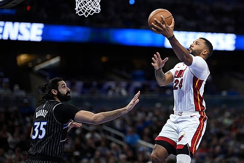Miami Heat guard Norman Powell (24) goes up to shoot as Orlando Magic center Goga Bitadze (35) defends during the first half of an NBA Cup basketball game in Orlando, Florida.
