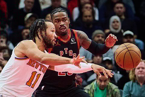 New York Knicks' Jalen Brunson (11) lines up a pass past Toronto Raptors' Jamal Shead during the first half of an NBA Cup basketball game in Toronto.