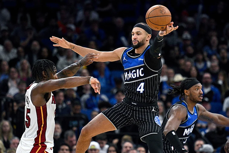 Orlando Magic guard Jalen Suggs (4) deflects a pass by Miami Heat guard Davion Mitchell, left, during the second half of an NBA Cup basketball game in Orlando, Florida. - | Photo: AP/Phelan M. Ebenhack