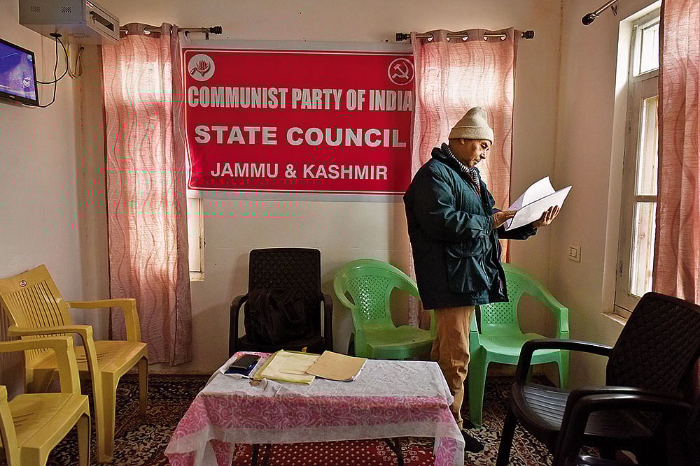 CPI member Mohammed Maqbool flips through a file in his party office in Srinagar, Kashmir 