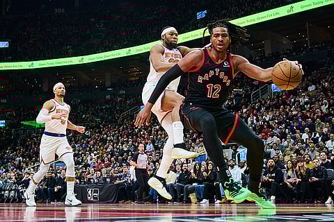 Toronto Raptors' Collin Murray-Boyles (12) drives past New York Knicks' Guerschon Yabusele (28) during the first half of an NBA Cup basketball game in Toronto.