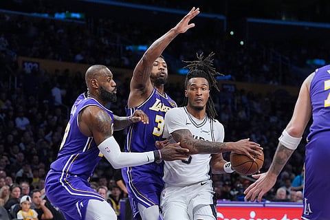 San Antonio Spurs guard Stephon Castle (5) is defended by Los Angeles Lakers forward Lebron James (23) and guard Marcus Smart (36) during the second half of an NBA Cup basketball game in Los Angeles.
