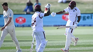 | Photo: AP/Andrew Cornaga : West Indies' Justin Greaves celebrates with teammate Kemar Roach after scoring 200 runs against New Zealand on Day 5 of their Test match on December 6, 2025.