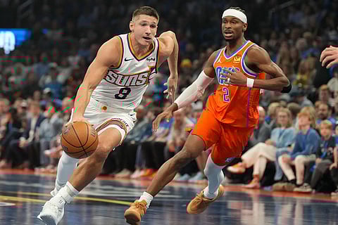 Phoenix Suns guard Grayson Allen (8) drives past Oklahoma City Thunder guard Shai Gilgeous-Alexander (2) during the first half of an NBA Cup basketball game in Oklahoma City.