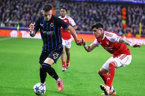 Brugge's Aleksandar Stankovic, left, fights for the ball with Arsenal's Piero Hincapie during the Champions League opening phase soccer match between Club Brugge and Arsenal in Bruges, Belgium.