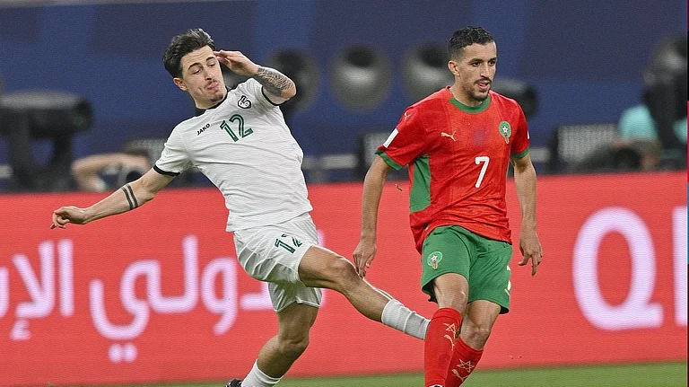 Syria's Antonio Yakoub challenges for the ball against Morocco's Mohamed Boualcsout during their FIFA Arab Cup match on December 11, 2025. - | Photo: X/EnMaroc